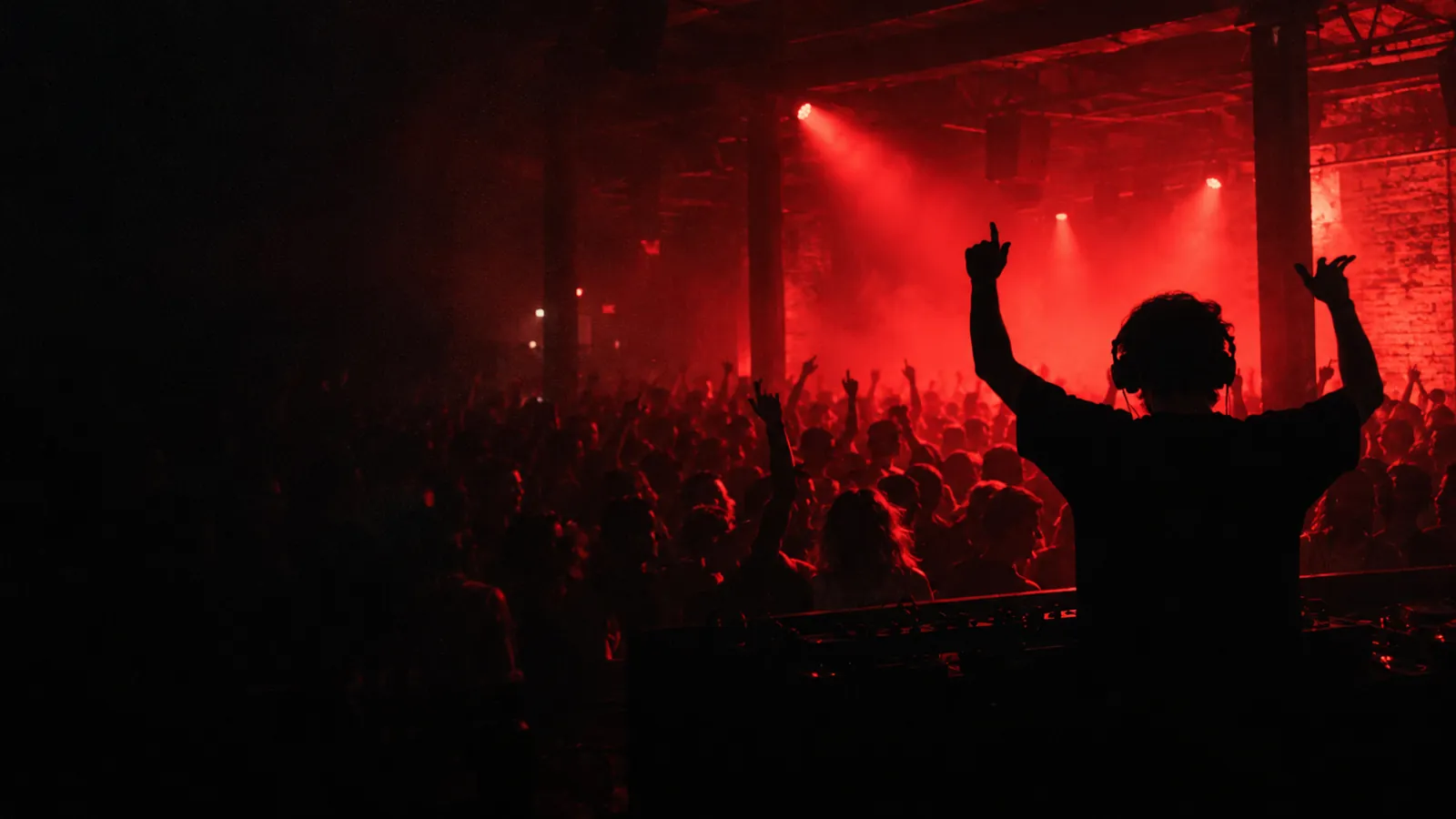 DJ with arms raised over the crowd